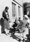 Barn och en fröken utomhus. Holtermanska daghemmet, okänt årtal.
