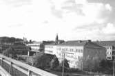 Vy västerut från Mölndals bro mot Broplatsen och kyrkan. Mölndalsbro i dag - ett skolpedagogiskt dokumentationsprojekt på Mölndals museum under oktober 1996. 1996_1005-1023 är gjorda av högstadieelever från Kvarnbyskolan 9A, grupp 6. Se även 1996_0913-0940, gruppbilder på klasserna 1996_1382-1405 samt bilder från den färdiga utställningen 1996_1358-1381.