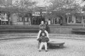 Ungdomar vid skulpturen Albert på Mölndals torg. Mölndalsbro i dag - ett skolpedagogiskt dokumentationsprojekt på Mölndals museum under oktober 1996. 1996_1098-1115 är gjorda av högstadieelever från Kvarnbyskolan 9C, grupp 5. Se även 1996_0913-0940, gruppbilder på klasserna 1996_1382-1405 samt bilder från den färdiga utställningen 1996_1358-1381.