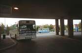 Buss och spårvagn under/vid ändhållplatsen/vändslingan Broplatsen. Mölndalsbro i dag - ett skolpedagogiskt dokumentationsprojekt på Mölndals museum under oktober 1996. 1996_1338-1356 är gjorda av högstadieelever från Åbyskolan 8A, grupp 6. Se även 1996_0913-0940, gruppbilder på klasserna 1996_1382-1405 och bilder från den färdiga utställningen 1996_1358-1381.