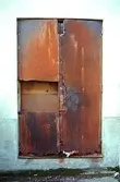 En rostig och trasig dörr i Mölndals Kvarnby, 1996.