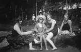 Några kvinnor och ett barn sitter på stranden vid Tulebosjön, 1930-tal.