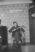 På bilden spelar Lasse Mattsson, kamrat till Vitalis Örtlund, mandolin i  Åkes,  Annas och Vitalis föräldrahem. Bild från början av 1930-talet.