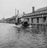 På huset t.h i bild står fabriksförsäljningen, enligt Karl är kortet taget mot spårvagnshallarna vid Mölndalsbro. Kortet är taget i samband med  översvämningen i Mölndal i februari 1943.