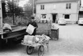 Förste postiljon John Stjärna, som transporterar posten från Alvesta, lastar av posten från lastbilen för att lämna den på poststationen i Delary.