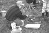 Familjesöndag vid Börjesgården, 1994-05-15. Museitekniker Alf Garthman steker mat på egengjord grill av stenar, tegel och ugnsplåt.