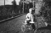 Karin Pettersson (gift Hansson) har fått en ny trehjuling att leka med utanför huset på Gamlehagsvägen 11 i Torrekulla, 1948.