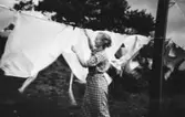 Rosa Krantz (gift Pettersson) hänger tvätt utanför personalbostaden på Stretered, 1922-1925.