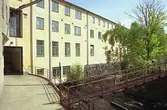 Vy från en cementplattform, på en gångbro över forsen och f.d strumpfabriken 