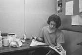 Bo Ternmalm sitter och läser en tidning i personalrummet.
Bilden ingår i serie från produktion och interiör på pappersindustrin Papyrus, 1980-tal.