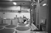 En man i arbete på pappersfabriken. Bilden ingår i serie från produktion och interiör på pappersindustrin Papyrus, 1980-tal.