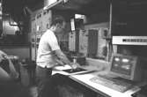 Denny Andersson i arbete, 1980-tal.
Bilden ingår i serie från produktion och interiör på pappersindustrin Papyrus.