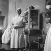 Undersköterska Syster Barbro på operation 1 vid Sabbatsbergs sjukhus i Stockholm, cirka 1958. Dagarna brukade börja kl 06.30. Slutade när de olika dukarna och instrumenten var torkade och räknade. Ofta omkring kl 22.00!