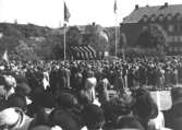 Invigning av Gunnebo slott den 16 maj 1952 på Nya torget i Mölndal. Kung Gustav VI Adolf  (1882 - 1973) inviger och firar. Huset till höger är Kvarnbyskolan. Till vänster därom ses Trädgårdsskolan (även kallad Träskolan). I bakgrunden ses Störtfjället.