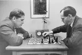 Gunnar Svensson från Malmö 17 t.v. och Gustaf Nillson, Malmö 1,
kopplar av vid ett schackbräde och klocka.