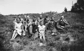 Sommar i Lindome, början av 1940-talet. Berit Gustafsson, några män och en pojke fikar i gröngräset.