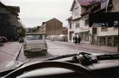 Frölundagatan i Mölndals centrum på 1960-talet. Vy från en bil i riktning mot väster.