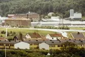 Vy över bostadsbebyggelse i Brännås mot byggnader i Åbro industriområde. Mölndal på 1970-talet.