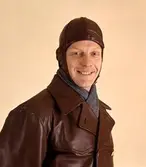 Brevbärare fotograferad iklädd motorhuva och skinnrock. Bilden är
införd i 1962 års beklädnadsreglemente. Plaggen utgjorde
skyddspersedlar och tilldelades de uniformspliktiga tjänstemännen vid
behov. Motorhuvan är av getnappa med löstagbar innerhuva av flanell.