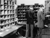 Tf förste postexpeditör Sven Drott sorterar brev på
postkontoret Stockholm 1, avgående utrikes, 1950.