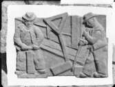 Relief med stenläggare av skulptören William Marklund
