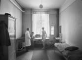 Truppförbandssjukhus, Gävle I14
Läkarmottagning med personal och patient
Interiör