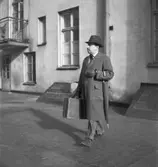 Ervacoreklam för herrkläder
Man med hatt, rock, paraply och resväska går över en bakgård
Exteriör