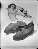 Skor och i bakgrunden en kvinna med flagga