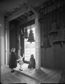 Historiska museet
Kvinna och flicka tittar på utställda kyrkklockor
Interiör
