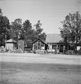 Bebyggelse vid landsväg
Färgaffär som även säljer parfym och sjukvårdsprodukter
Varor utställda på gårdsplanen 
Exteriör