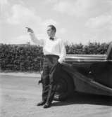 Bebyggelse vid landsväg
Man lutad mot bil
Exteriör