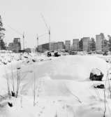 Byggarbetsplats
Exteriör, byggnader under uppförande i fonden. Öppet fält under snötacke i förgrunden.