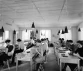 Hushållsseminarium
Interiör, undervisningssal med elever sittandes i bänkar, konformade lampor i taket