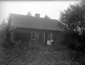 Oidentifierad kvinna som sitter på farstutrappen. Eventuellt Anna i Ekeflo?