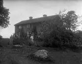 Familj utanför hus.