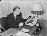 Personal: Herr Sahlenius vid skrivbord, omslagsbild med damer och böcker