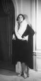 Modell i kappa i svart sammet med vit hermelinkrage. Från Jean Patou.