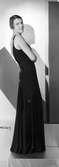 Modell i svart aftonklänning med glittriga inslag.