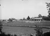 Bärbystugan och Nyvlastugan på friluftsmuseet Disagården, Gamla Uppsala under återuppförande midsommar 1929