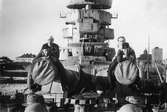Fyra män sittande på de förliga 28 cm kanonerna på ett pansarskepp av Sverige-klassen.