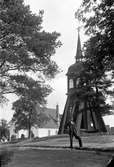 En man står framför Solberga klockstapel vid Bäckaby kyrka i Jönköpings Stadspark.