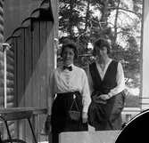 Två servitriser utanför en servering.