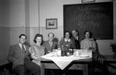 Sex personer bland annat Allan Ståhl (1) och Majken Fält (2) sitter vid ett dukat bord i en lokal i Jönköping. På tavlan på väggen bakom dem står texten: Välkomna till sillsexan 21/7 1944.