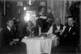 I en lägenhet i Jönköping sitter Gustav Andersson (till vänster), tillsammans med bland andra sin far Johan August, vid ett kaffebord.