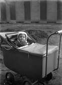 Ett barn i en barnvagn vid 