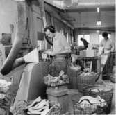 Män arbetar vid olika maskiner för skotillverkning. En stor del av produktionen består av träskor med namnet Dalbo. Holm Se hembygden 1972, s. 156