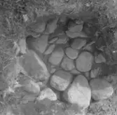 Stenpackningen framrensad i gropen, anl. 23. Lena.