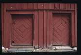 Panelklädd bräddörr på en f.d. handelsbod från 1700-talet. Dörren är klädd med profilerade bräder som bildar ett diagonalt rutmönster. Månstad