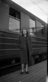 Kvinna på perrong vid tåg.