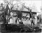 Anders Johanssons fotosamling. Skolpojkar hjälper till med tegellangning vid taktäckning.  Främmestad